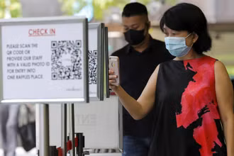 Quét QR code để vào một trung tâm thương mại tại Singapore. (Ảnh: Reuters)