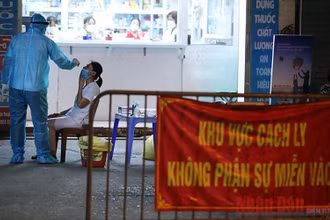 Lấy mẫu xét nghiệm khu vực có ca mắc Covid-19. (Ảnh: DUY LINH)