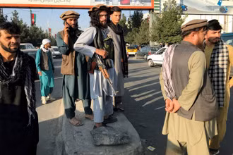 Một tay súng Taliban (giữa) đứng bên ngoài sân bay quốc tế Hamid Karzai, tại Kabul, ngày 16/8. (Ảnh: Reuters)
