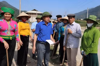 Ông Lò Văn Pháng (đứng giữa áo xanh) vận động người dân làm đường giao thông nông thôn.