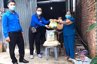 Đội hình áo xanh tình nguyện miệt rừng U Minh hạ hỗ trợ mang thực phẩm xuống nhà dân.