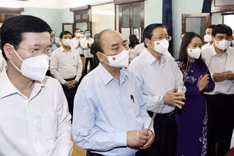 Chủ tịch nước Nguyễn Xuân Phúc và các thành viên trong đoàn thành kính dâng hoa, dâng hương tại Nhà 67. (Ảnh: TTXVN)