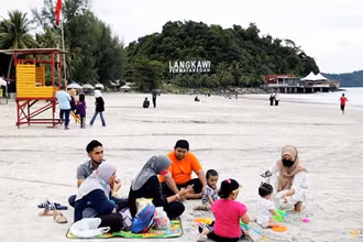 Du khách nghỉ ngơi trên bãi biển ở Langkawi theo mô hình "bong bóng du lịch" (Ảnh: REUTERS)
