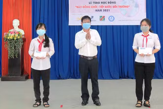 Ban tổ chức trao học bổng cho học sinh nghèo, hiếu học tại Trường THCS Tam Phước (huyện Châu Thành, tỉnh Bến Tre).