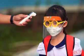 Đo thân nhiệt cho học sinh trước khi vào Trường tiểu học Thạnh An, huyện Cần Giờ, TP Hồ Chí Minh. (Ảnh: HẢI LONG)
