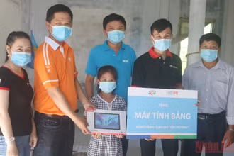 Học sinh có gia cảnh khó khăn được trao tặng máy tính bảng để phục vụ cho việc học tập. (Ảnh: MINH KHỞI)