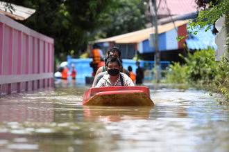 Người dân đi thuyền qua một con đường bị ngập nặng ở tỉnh Lopburi, Thái Lan. (Ảnh: Reuters)