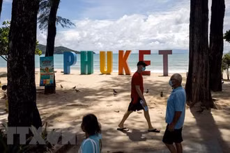 Du khách dạo chơi trên bãi biển ở Phuket, Thái Lan ngày 14/8/2021. (Ảnh: AFP/TTXVN)