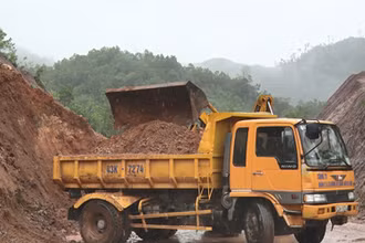 Huy động phương tiện khắc phục sạt lở đất lấp đường.