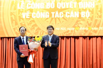 PGS, TS Nguyễn Duy Bắc, Phó Bí thư Đảng ủy, Phó Giám đốc Học viện Chính trị quốc gia Hồ Chí Minh trao quyết định và tặng hoa chúc mừng PGS, TS Mai Đức Ngọc.