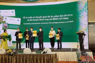 Thứ trưởng Nông nghiệp và Phát triển nông thôn Lê Quốc Doanh trao bản đồ đồ rủi ro và thích ứng biến đổi khí hậu vào nông nghiệp cho đại diện Sở Nông nghiệp và Phát triển nông thôn các địa phương. (Ảnh: THANH TRÀ)
