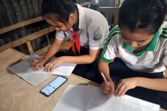 Nhiều học sinh thiếu thiết bị học trực tuyến, phải học chung bằng điện thoại di động.