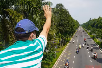 Tác giả vẫy tay chào anh chị em công nhân từ Đồng Nai về quê các tỉnh Tây Nguyên. (Ảnh Phước Tuấn).