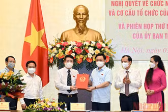 Chủ tịch Quốc hội Vương Đình Huệ trao Nghị quyết cho Viện trưởng Viện Lập pháp Nguyễn Văn Hiển. (Ảnh: Duy Linh)