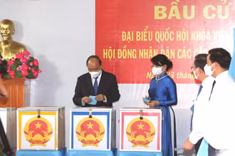 Chủ tịch nước Nguyễn Xuân Phúc cùng phu nhân bỏ phiếu tại khu vực bỏ phiếu số 041, đơn vị bầu cử số 9, thị trấn Củ Chi, huyện Củ Chi, TP Hồ Chí Minh.
