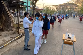 Đo thân nhiệt học sinh khi đến trường.
