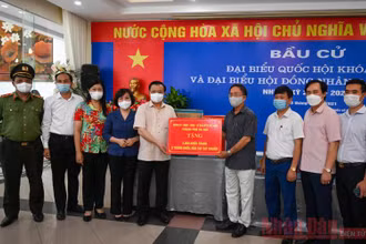 Bí thư Thành uỷ Đinh Tiến Dũng tặng quà hỗ trợ công tác phòng, chống dịch Covid-19 cho Tổ bầu cử số 8, phường Phú Thượng, quận Tây Hồ. (Ảnh: Duy Linh)