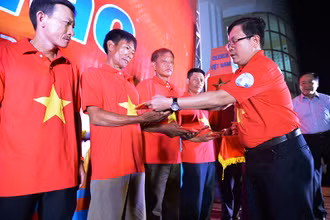 Đồng chí Tô Đình Tuân, Tổng Biên tập Báo Người Lao Động trao cờ cho ngư dân.