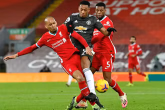Martial (áo sẫm, Man United) bị “kẹp” giữa Fabinho (trái) và Wijnaldum trong lần gặp Liverpool trên sân Anfield.	