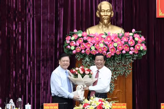 Phó Chủ nhiệm thường trực Ủy ban Kiểm tra Trung ương Trần Văn Rón tặng hoa chúc mừng tân Bí thư Tỉnh ủy Vĩnh Long Bùi Văn Nghiêm. 