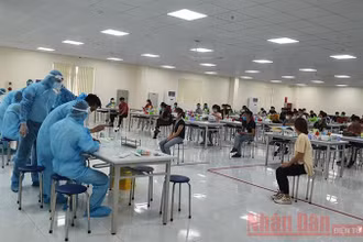 Lực lượng y tế lấy mẫu xét nghiệm Covid-19 cho công nhân tại KCN Vân Trung (Ảnh minh họa: Đặng Giang).