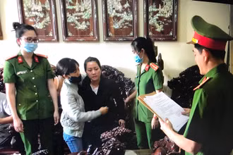 Điều tra viên đọc Lệnh bắt tạm giam với Huyền (áo đen thứ 3 từ trái qua) tại nhà riêng của đối tượng.