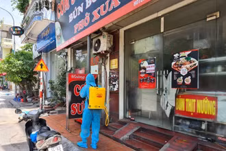 Lực lượng chức năng phun thuốc khử khuẩn quán cơm sườn Nam Bộ ở phường Trần Hưng Đạo, TP Hạ Long.
