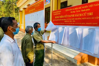 Cử tri thôn Muồng xã Dương Hưu, huyện Sơn Động, Bắc Giang nghiên cứu danh sách cử tri tại điểm niêm yết.