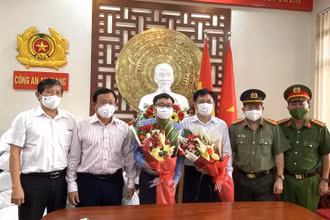 Đại diện Công an tỉnh An Giang tặng hoa cảm ơn Công ty ANGIMEX đã hỗ trợ người dân huyện An Phú.