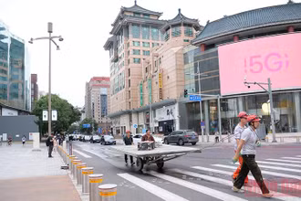 Người lao động không đeo khẩu trang đi qua một ngã tư. (Ảnh: VI SA)