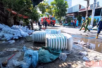 Lực lượng chức năng cùng người dân giải cứu tài sản cho chủ cơ sở sản xuất.