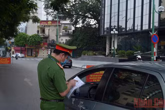 Lực lượng chức năng kiểm tra giấy đi đường của người dân tại lưu thông trên tuyến đường Thanh Niên (Hà Nội). Ảnh: Minh Hà