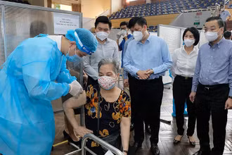 Bộ trưởng Nguyễn Thanh Long kiểm tra điểm tiêm ở nhà thi đấu Trịnh Hoài Đức, thăm hỏi những người tới tiêm. (Ảnh: Bộ Y tế)