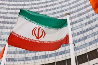 Quốc kỳ Iran trước trụ sở Cơ quan Năng lượng Nguyên tử Quốc tế (IAEA). (Ảnh: REUTERS)
