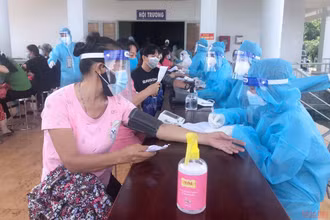 Đo huyết áp trước khi tiêm vaccine cho người dân tại Bình Dương.