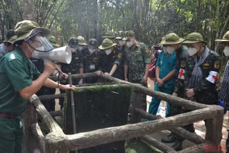 Du khách tham quan một hầm chông với nắp tự động của người dân Củ Chi. 