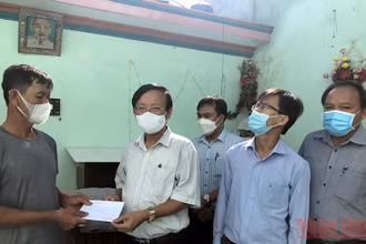Bí thư Huyện ủy Bình Sơn (Quảng Ngãi) Lương Kim Sơn trao tiền hỗ trợ cho gia đình có nhà bị hư hỏng do lốc xoáy.