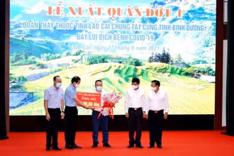 Lãnh đạo tỉnh tặng hoa và quà cho Đoàn y tế vào tỉnh Bình Dương chống dịch. (Ảnh: QUỐC HỒNG).