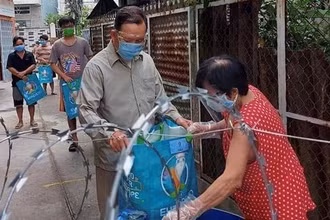 Người dân ở quận 12 nhận nhu yếu phẩm hỗ trợ của chính quyền địa phương.