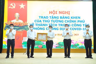 Chủ tịch UBND TP Hà Nội Chu Ngọc Anh trao Bằng khen của Thủ tướng Chính phủ cho nhân dân và cán bộ huyện Đông Anh về thành tích trong công tác phòng, chống dịch Covid-19.