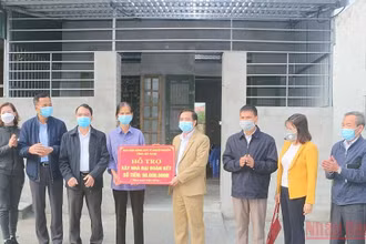 Đại diện lãnh đạo Ủy ban Mặt trận Tổ quốc tỉnh Hà Nam trao tiền hỗ trợ xây nhà "Đại đoàn kết" cho gia đình bà Đinh Thị Trụ. (Ảnh: ĐÀO PHƯƠNG) 