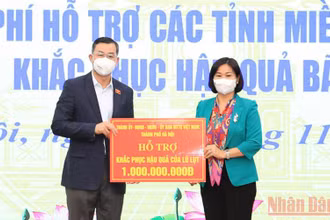 Lãnh đạo Thành ủy Hà Nội trao tiền hỗ trợ cho người dân tỉnh Hòa Bình bị thiệt hại vì bão lũ.