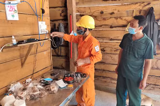 Công nhân Công ty Điện lực Kon Tum hướng dẫn cho người dân làng Dao, xã Ia Dom, huyện Ia H’Drai cách sử dụng điện an toàn. 