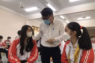 Thầy Lê Đắc Tường hỏi thăm sức khỏe các em học sinh sau khi tiêm vaccine Covid-19.