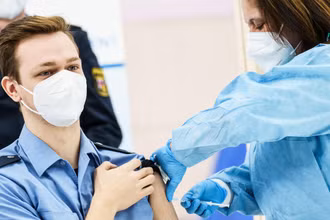 Một cảnh sát Đức được tiêm vaccine phòng Covid-19. Ảnh: dw.com