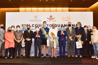 Phó Chủ tịch UBND tỉnh Quảng Nam Trần Văn Tân tặng hoa chúc mừng đại diện đoàn khách quốc tế đầu tiên đến Quảng Nam. (Ảnh: TẤN NGUYÊN)
