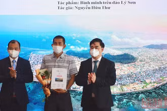 Ông Lê Hải Bình (bên trái) và PGS, TS Phạm Minh Tuấn trao giải nhất cho tác phẩm "Bình minh trên đảo Lý Sơn" của tác giả Nguyễn Hữu Thư.