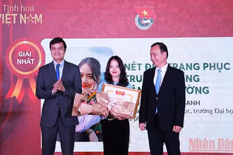 Đồng chí Bùi Quang Huy, Ủy viên dự khuyết Trung ương Đảng, Bí thư thường trực Trung ương Đoàn, Chủ tịch Hội Sinh viên Việt Nam (bên trái) trao giải nhất tặng tác giả Bùi Mai Anh. 