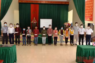 Đại diện lãnh đạo huyện Quỳ Hợp và phóng viên Báo Nhân Dân thường trú tại Nghệ An trao điện thoại thông minh cho các cháu học sinh nghèo hiếu học. 
