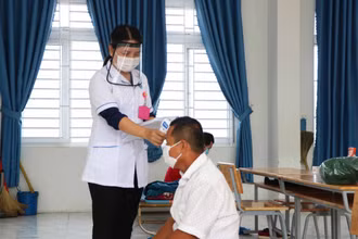 Nhân viên y tế đo thân nhiệt cho F0 tại khu cách ly tập trung huyện Thuận Nam ( Ninh Thuận).